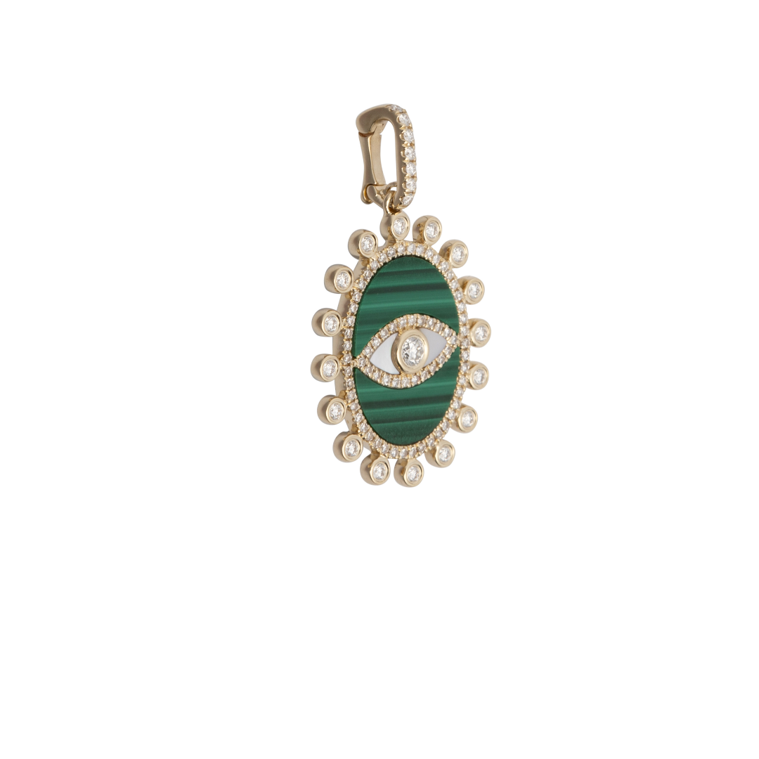 A sideways shot of a malachite and diamond evil eye pendant set on a white background.