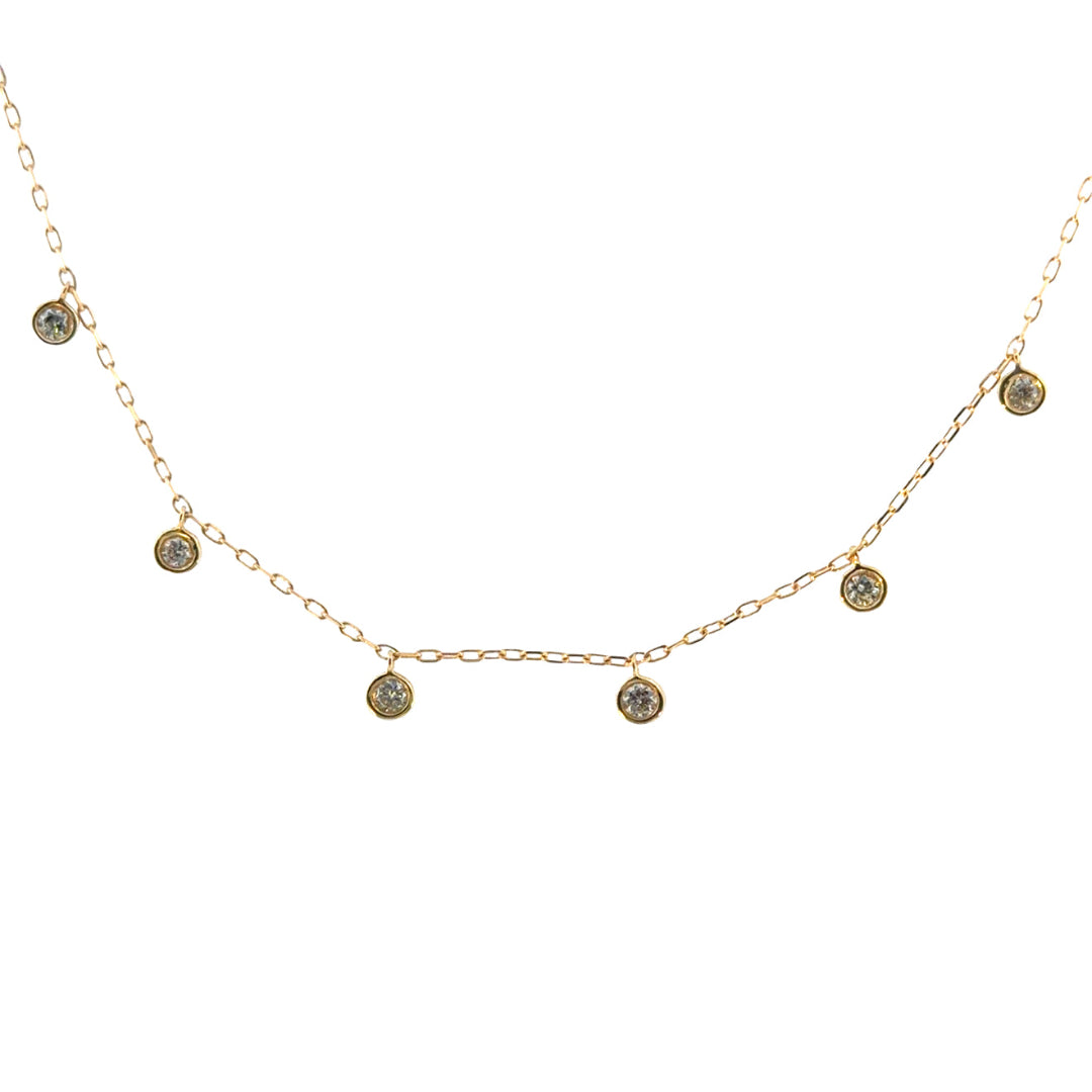 A delicate gold chain with bezel set diamonds suspended, on a white background.