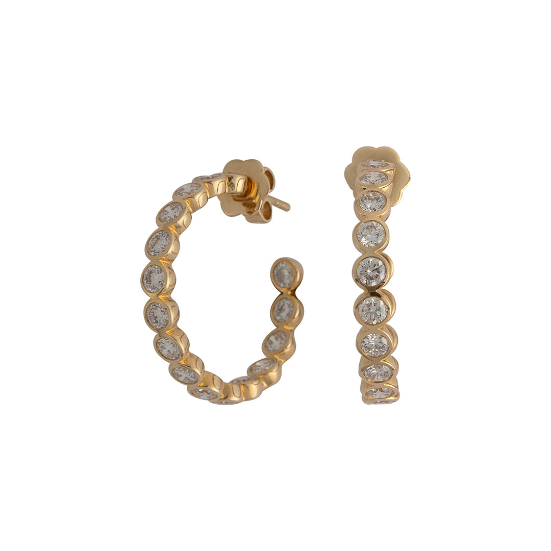 A pair of bezel set round lab-grown diamond C hoop earrings in 14k gold.