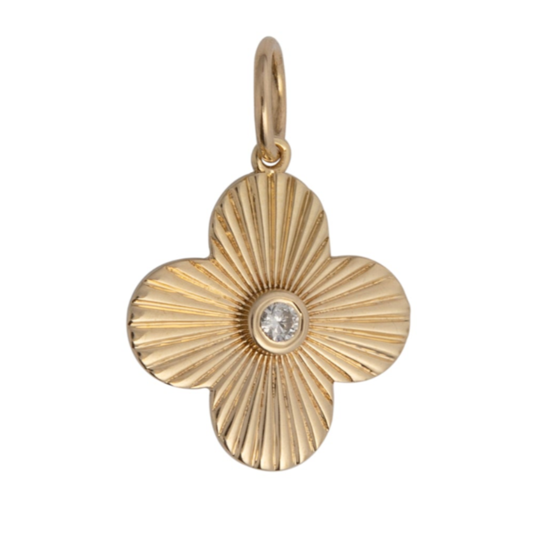 A gold-colored pendant featuring a clover-shaped design with a blue sapphire center stone.