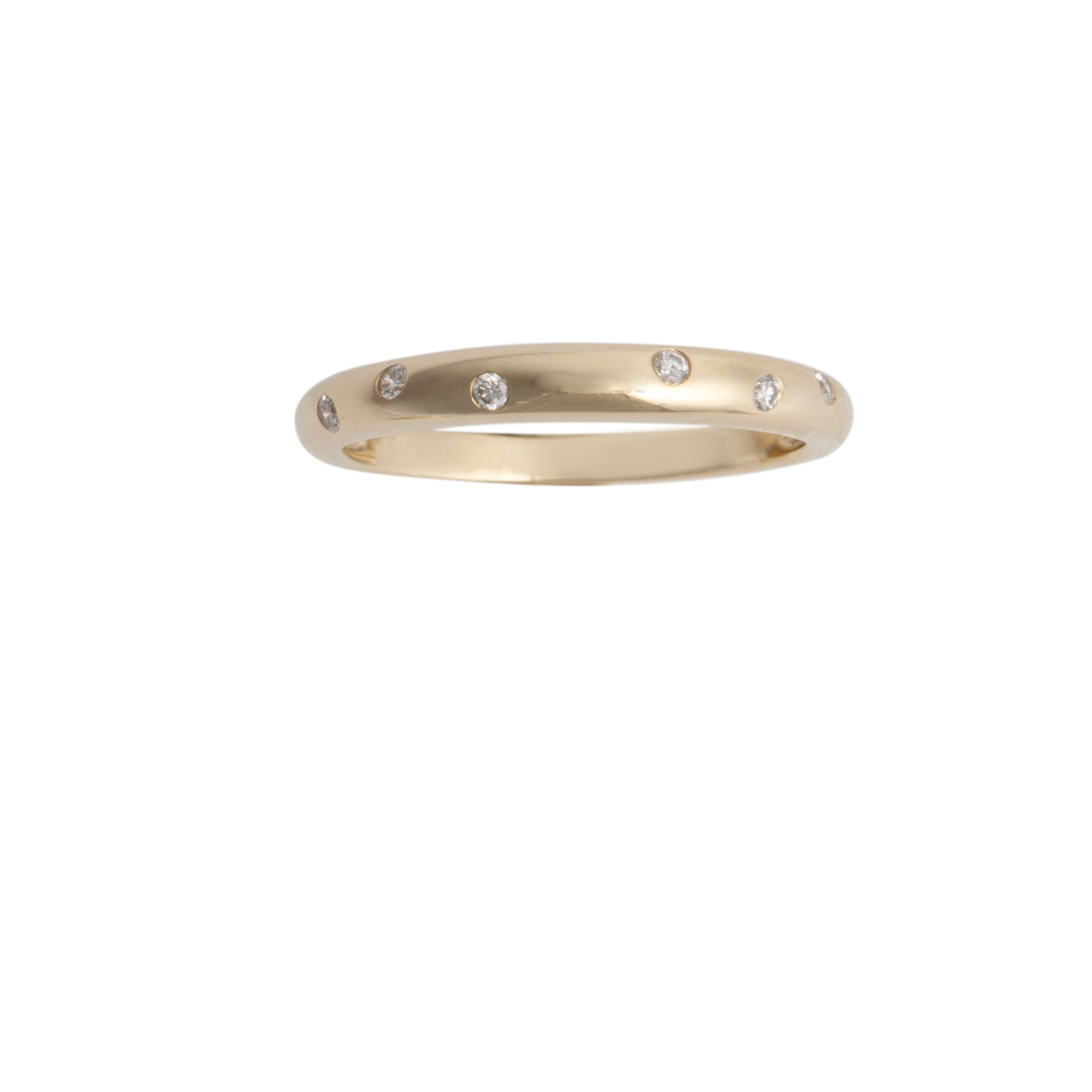 A gold band ring with diamonds set around the top edge.