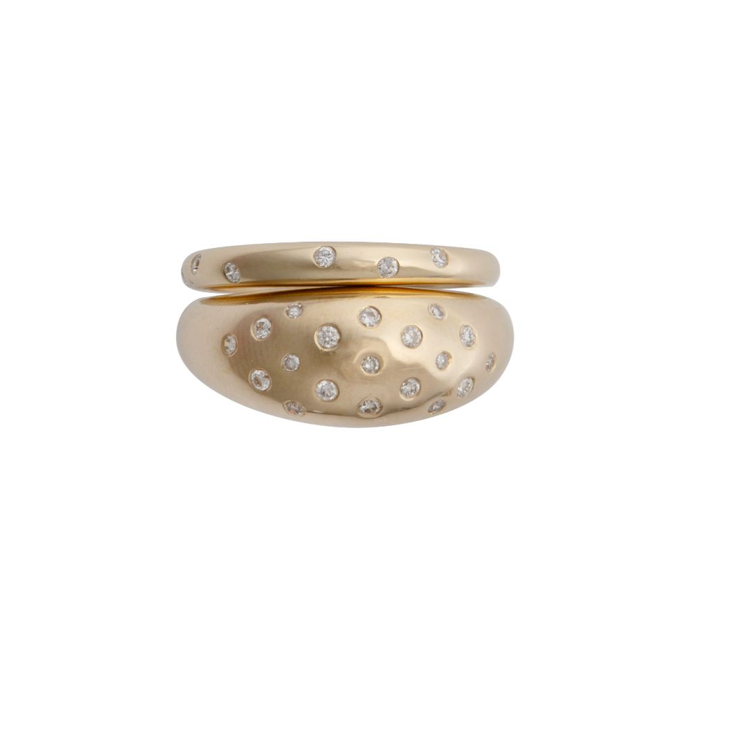 A 14k gold dome ring with small diamonds set around the top edge, layered with a thin gold band of the same style.
