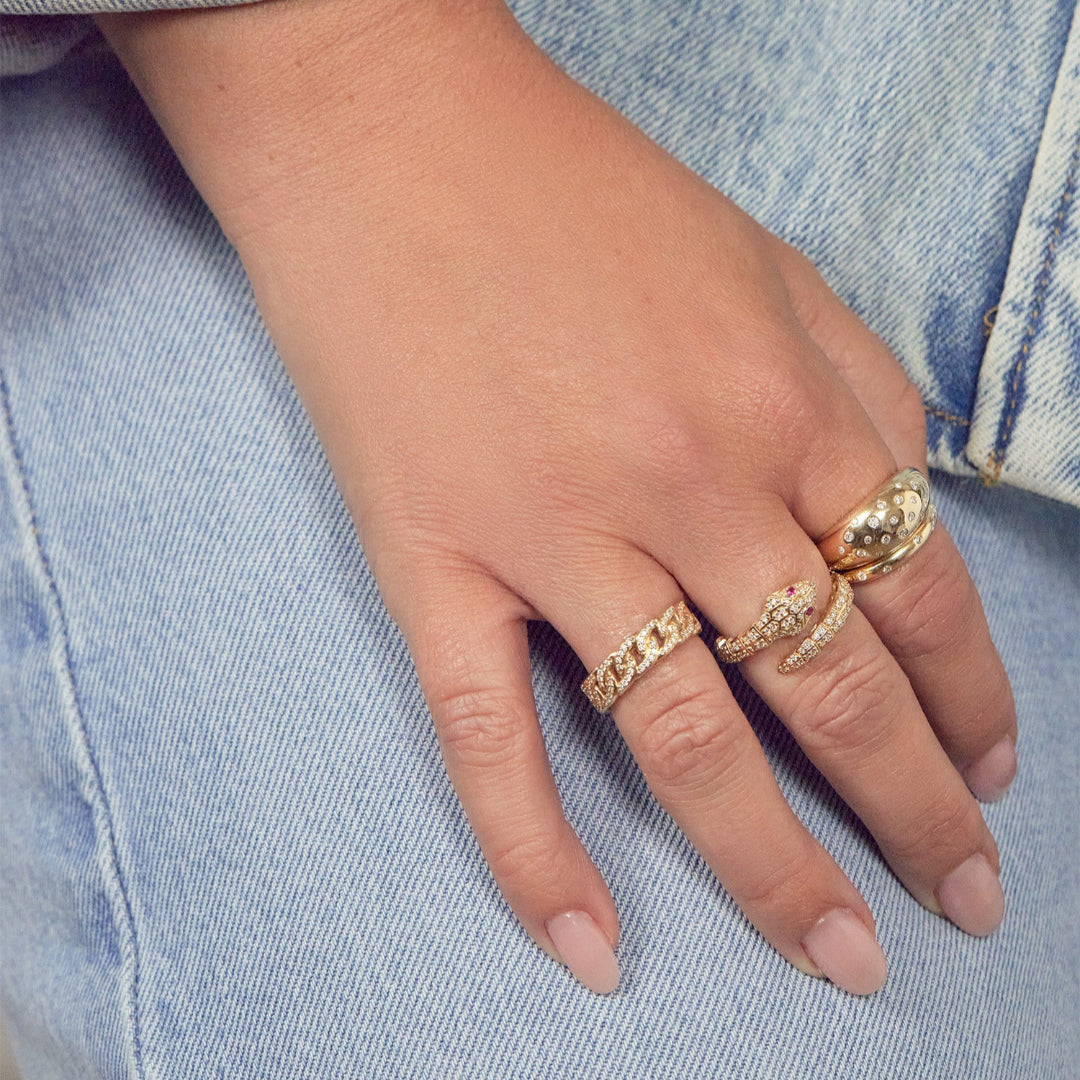 A person wearing three gold rings with diamonds.