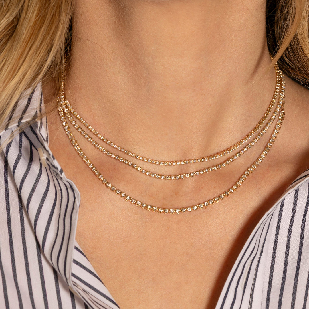 A woman wearing three diamond tennis necklace chokers.