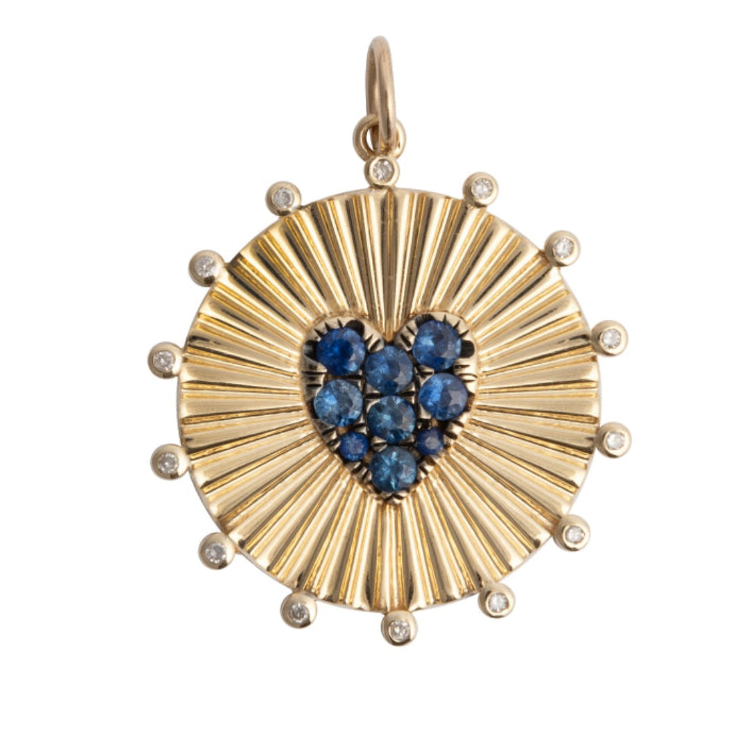 Gold pendant with a heart-shaped blue sapphires on a white background