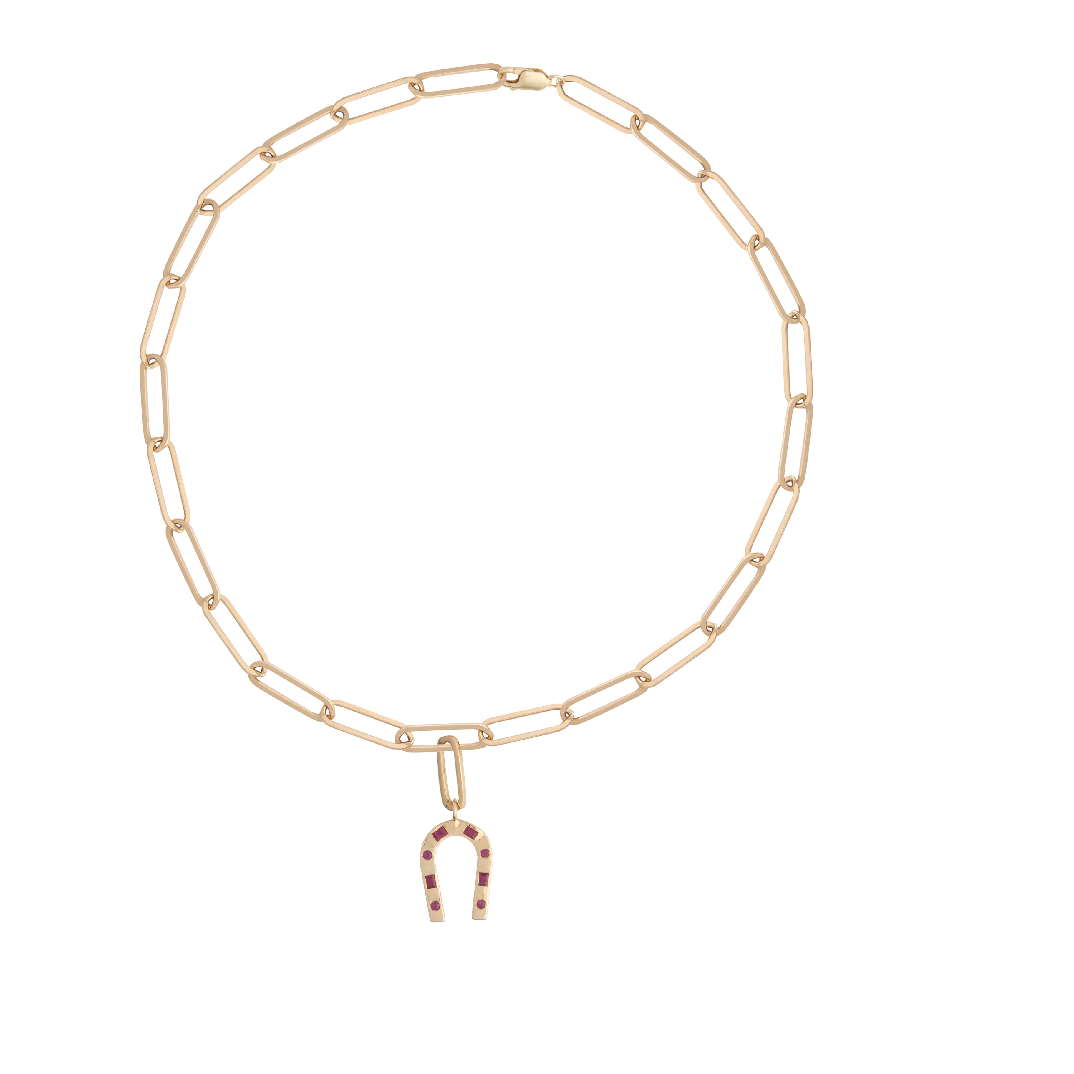 A 14k gold and ruby horseshoe pendant attached to the chain with an elongated oval gold pendant bail on a white background.