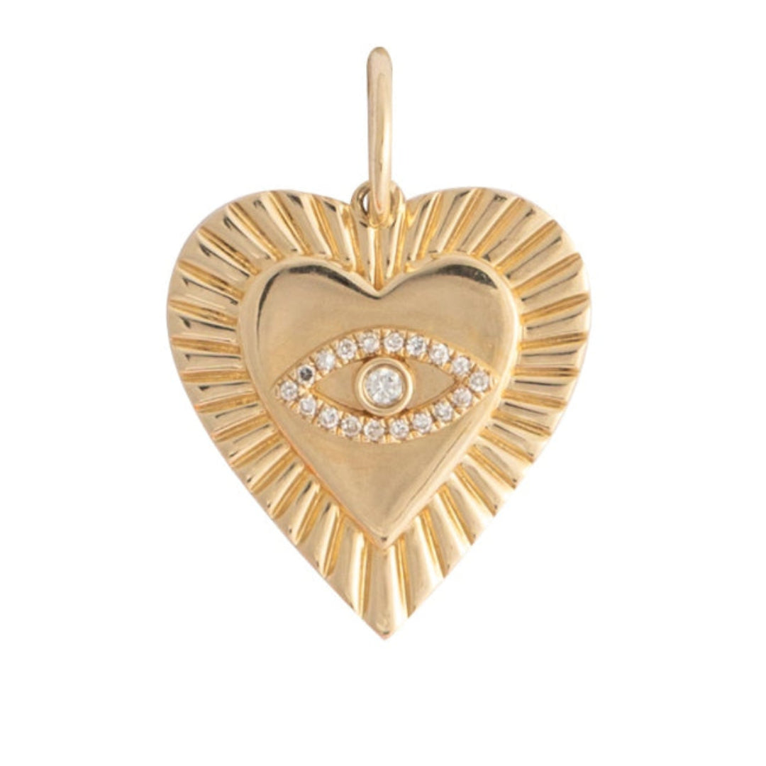 A gold heart pendant with an evil eye set on a
