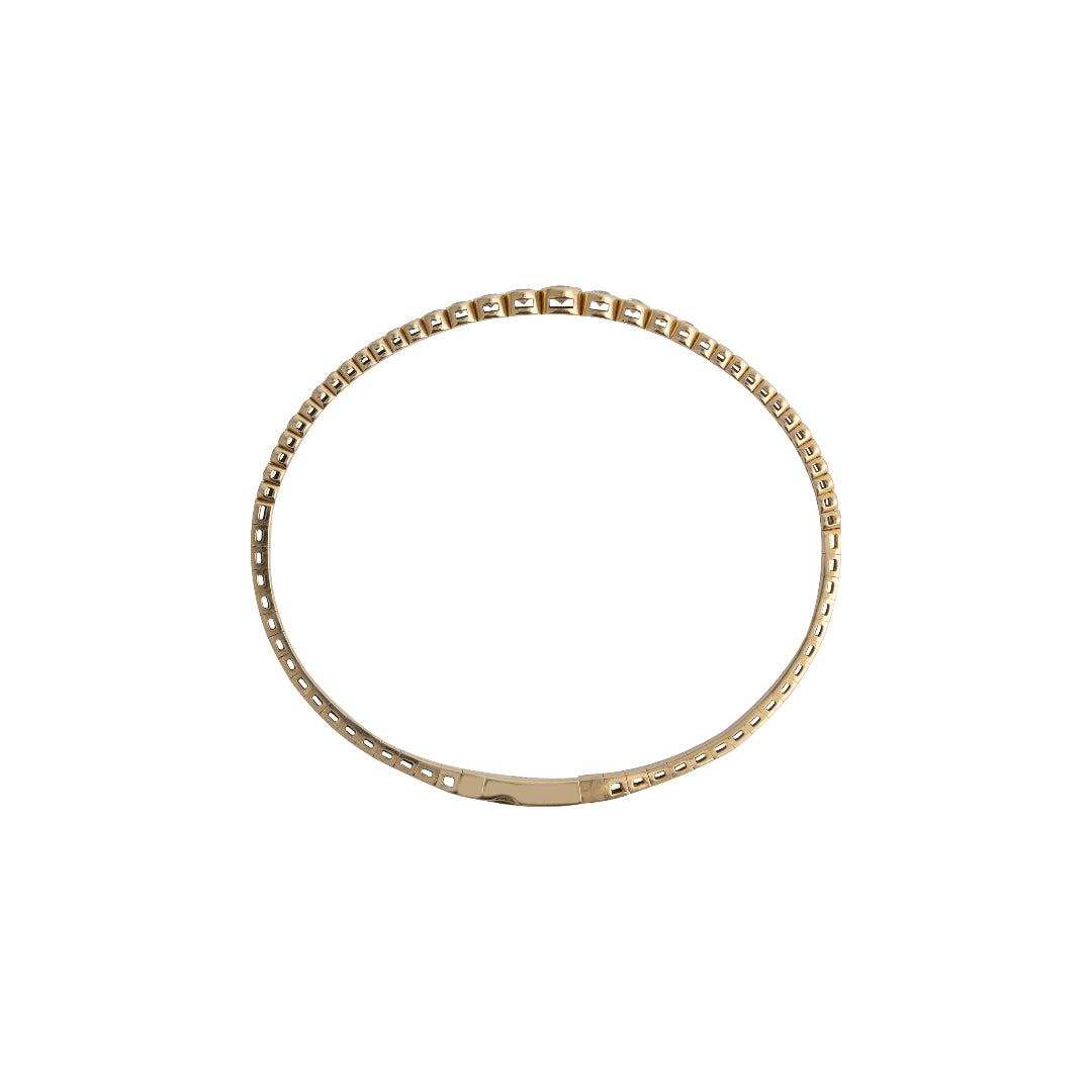 Sideways view of a gold bracelet on a white background
