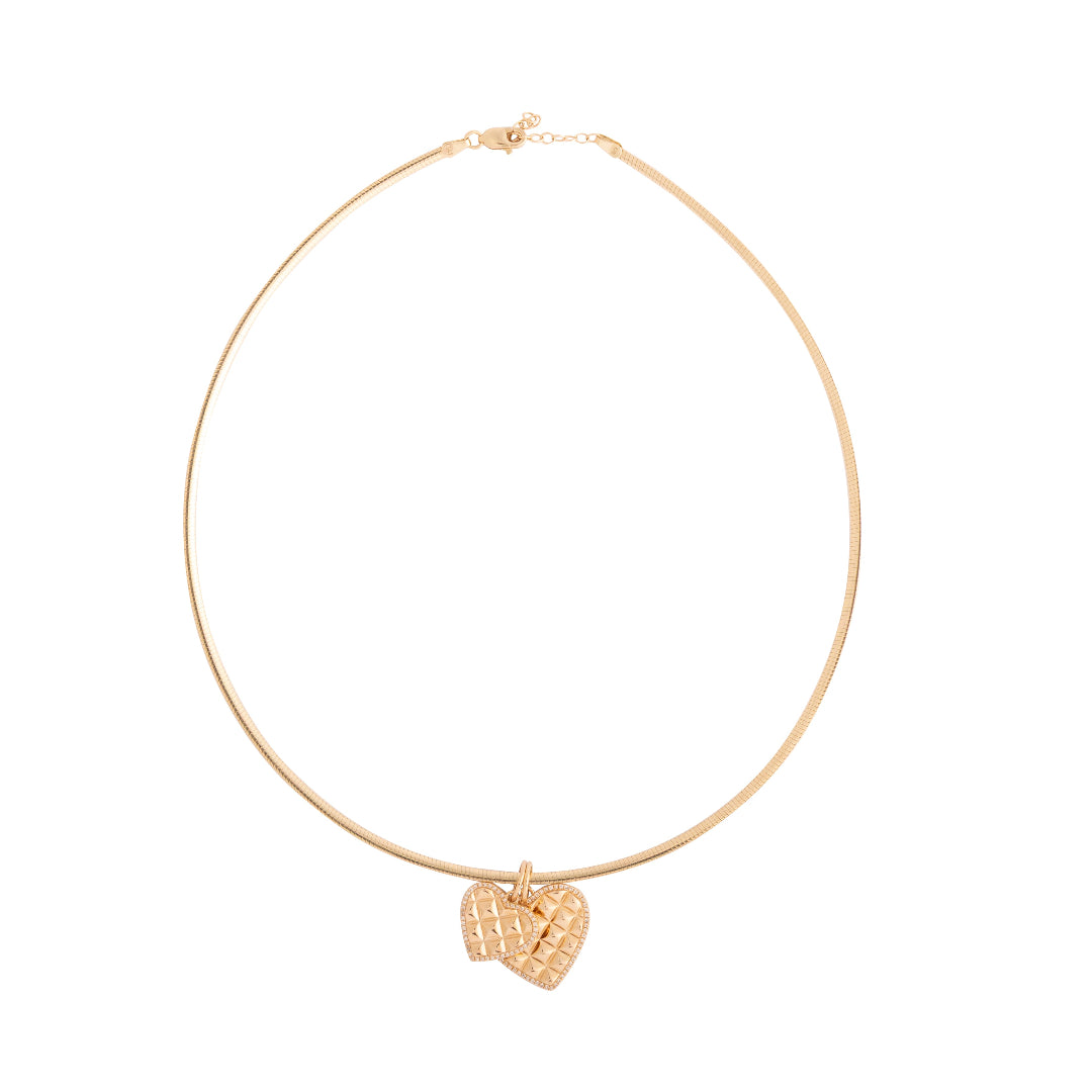 Gold necklace with a heart-shaped pendant on a white background
