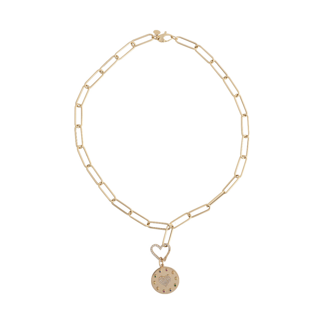 A paperclip chain necklace with a heart shaped gold and diamond pendant attached by a heart shaped diamond pave pendant bail, laid out on a white background.
