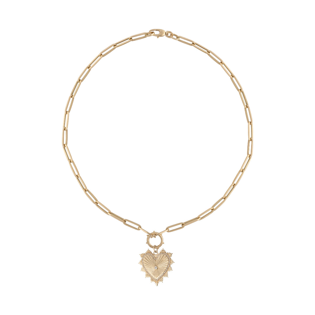 A 14k gold paperclip chain necklace with a beveled heart pendant attached with a pendant bail.