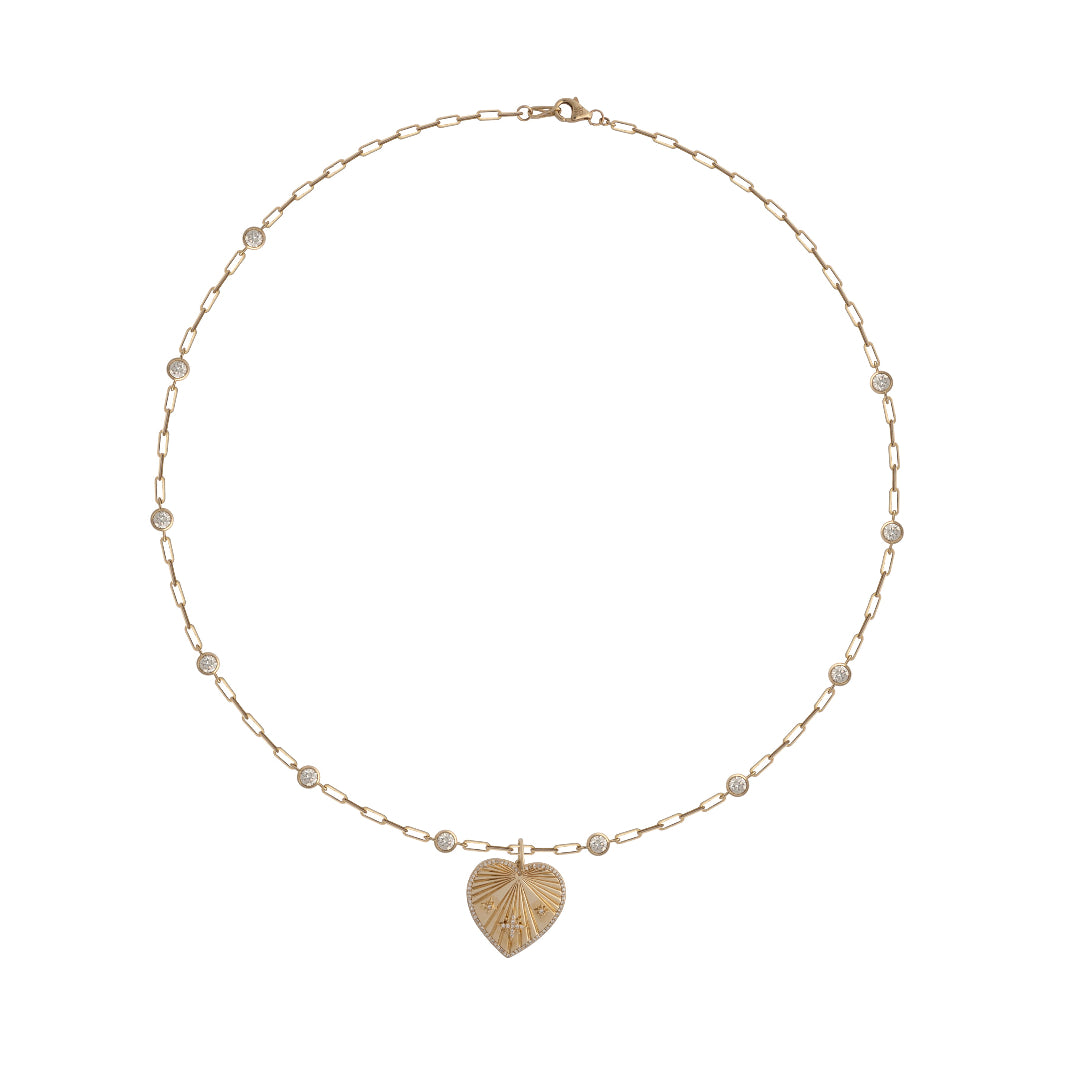 A white background with a gold diamond station necklace with a gold heart with diamonds.