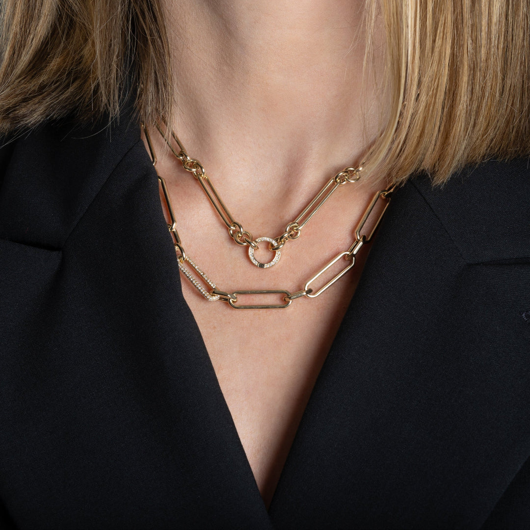 A person modeling two 14k gold necklaces with diamond links.