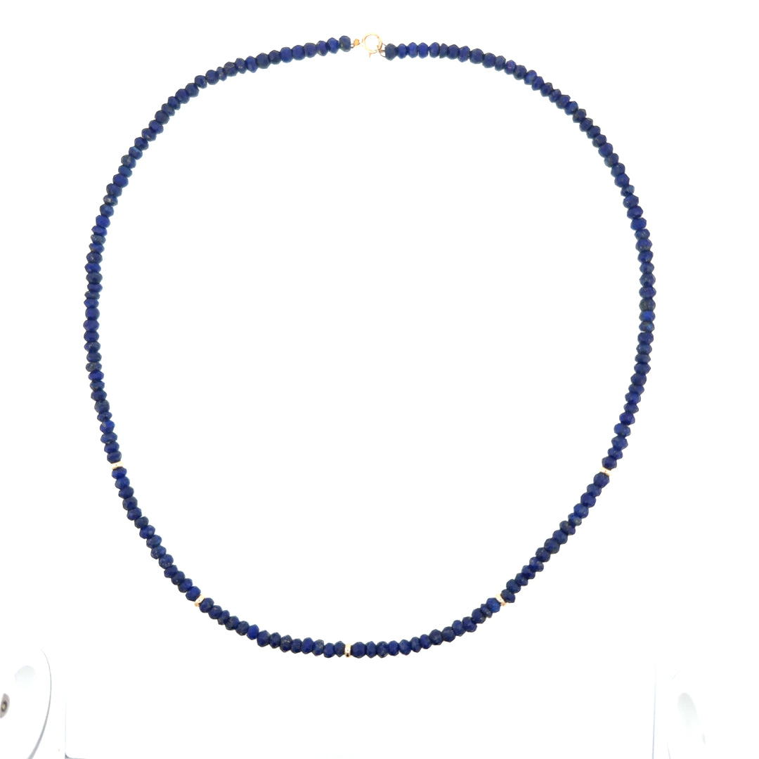 Natural lapis beaded necklace with 14k gold beads on a white background