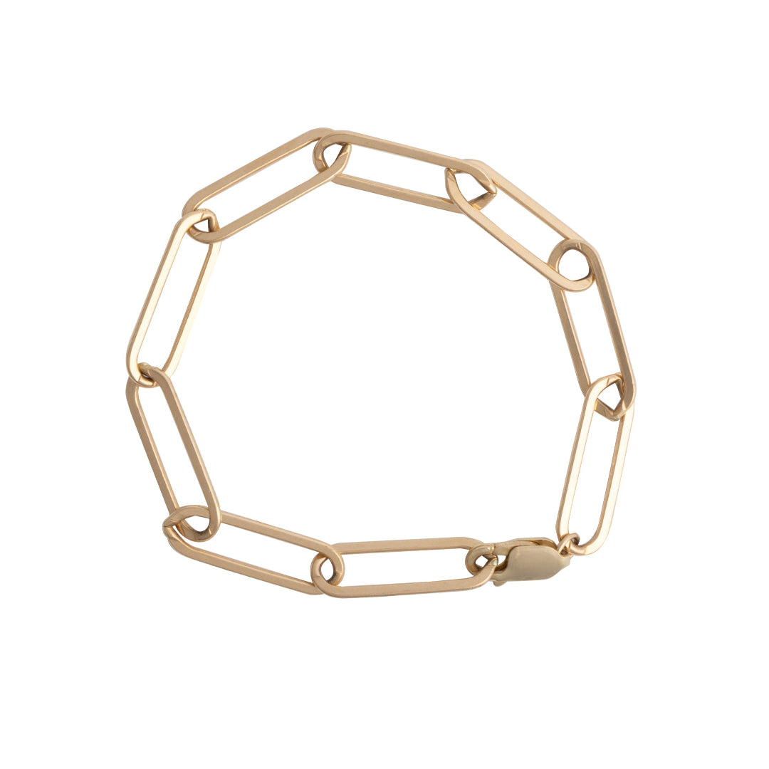 A gold paperclip chain bracelet displayed against a white background.