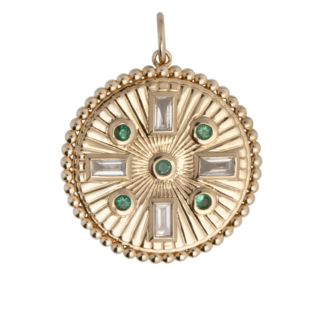 A gold-colored emerald and diamond pendant with a circular design, featuring a central emerald stone flanked by smaller diamonds on a white background.