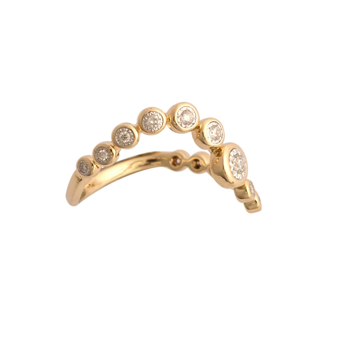 Gold ring with bezel set diamonds on a white background.