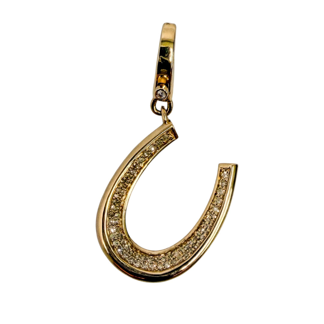 14k gold horseshoe-shaped pendant with pavé diamond stones on a white background.