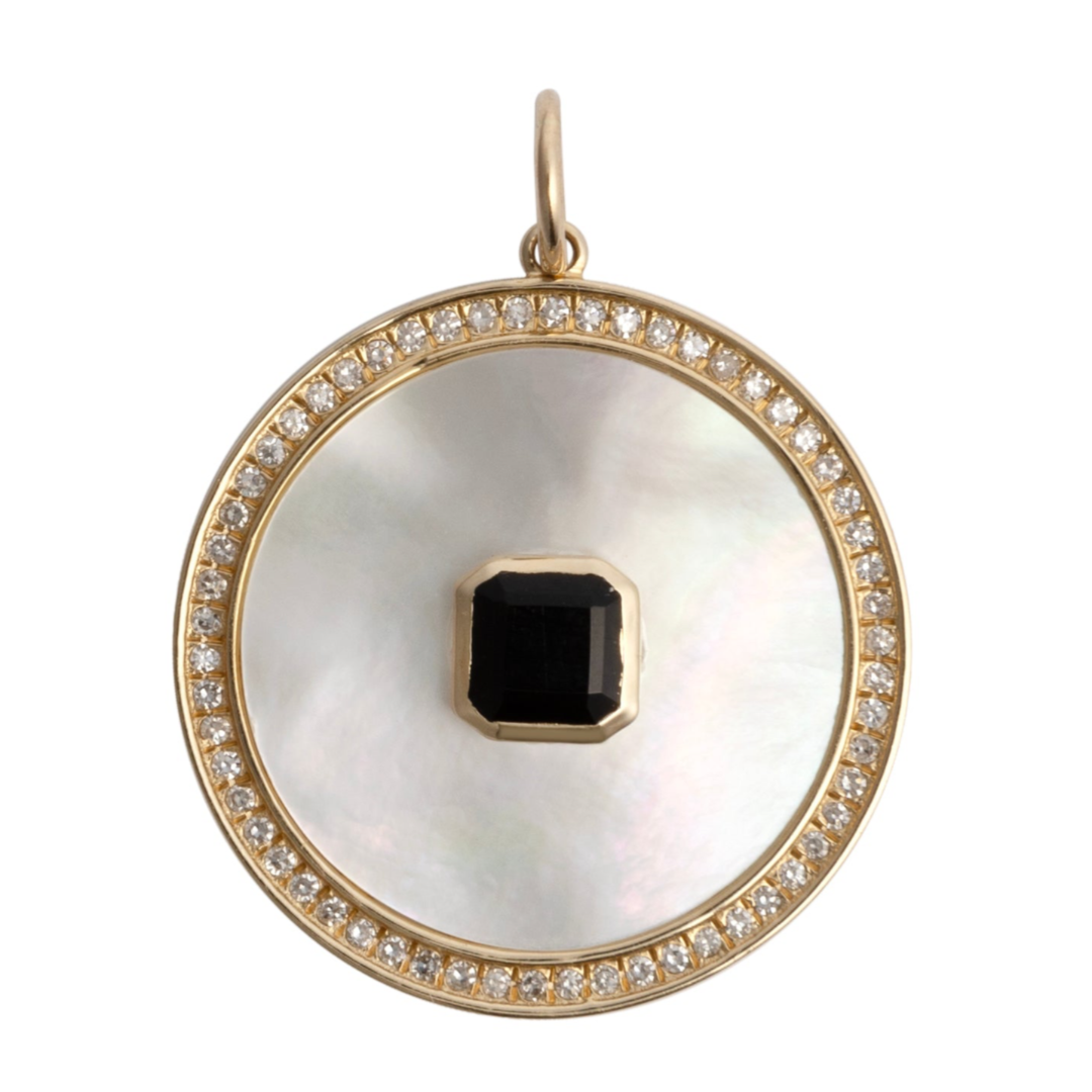 A gold pendant featuring a mother of pearl disc with a diamond and black onyx sun ray pattern, attached to a small gold chain.