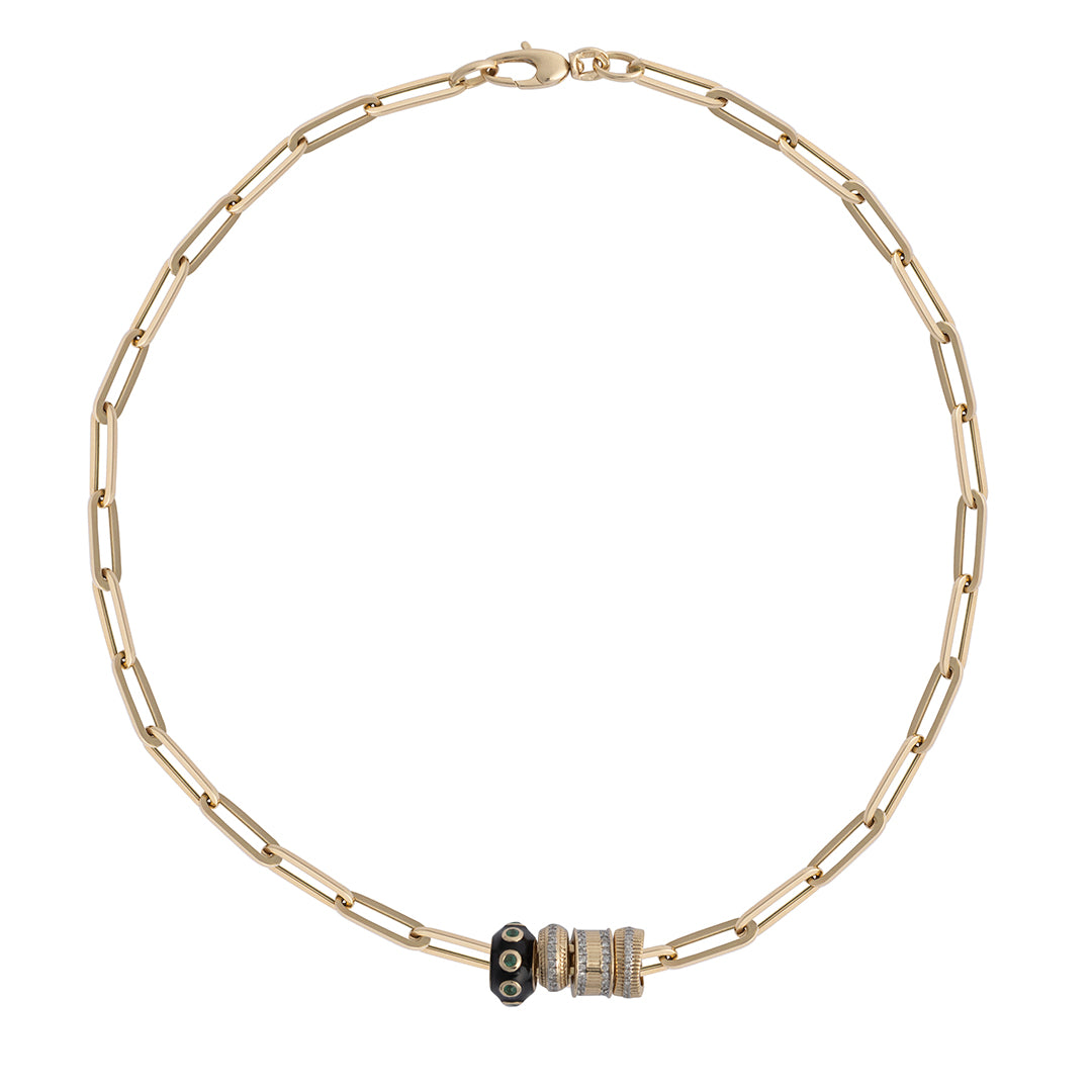 A 14k gold paperclip chain necklace with diamond and emerald roundel beads on a white background.