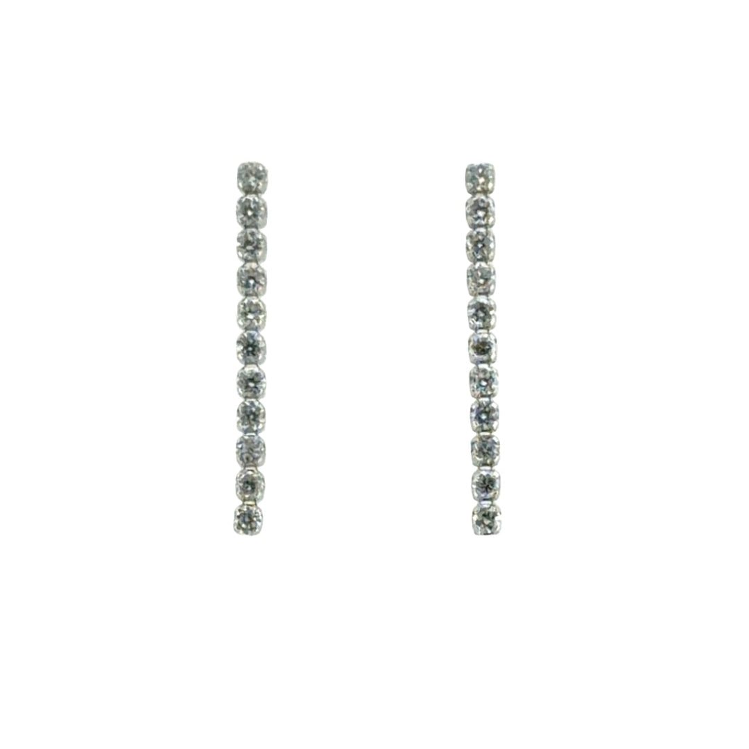A pair of white gold drop earrings, each featuring a vertical line of pavé diamonds in a prong setting, shown against a plain white background.