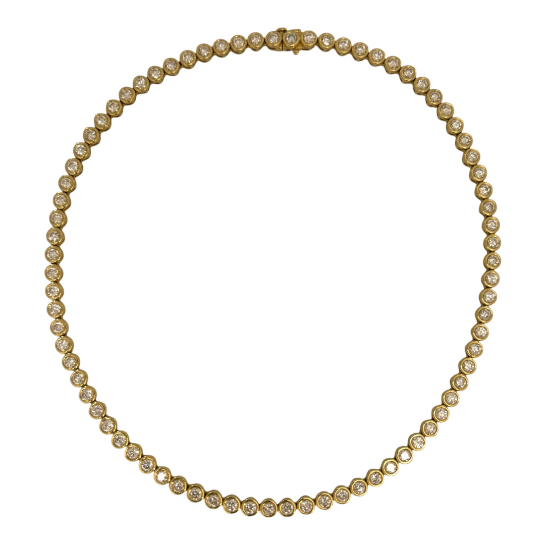 A 14k gold round bezel set tennis necklace on a white background.