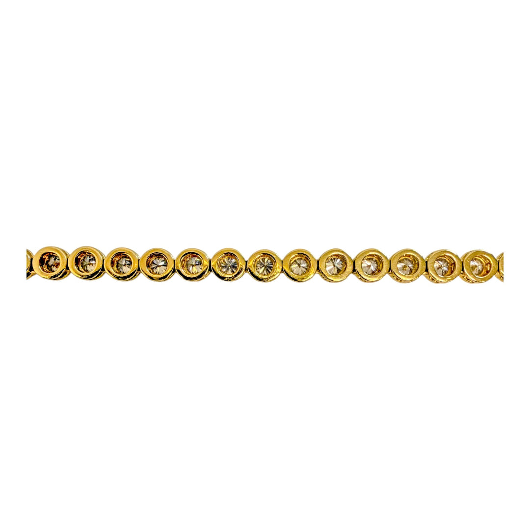A close up of the back of a 14k gold round bezel set necklace on a white background.