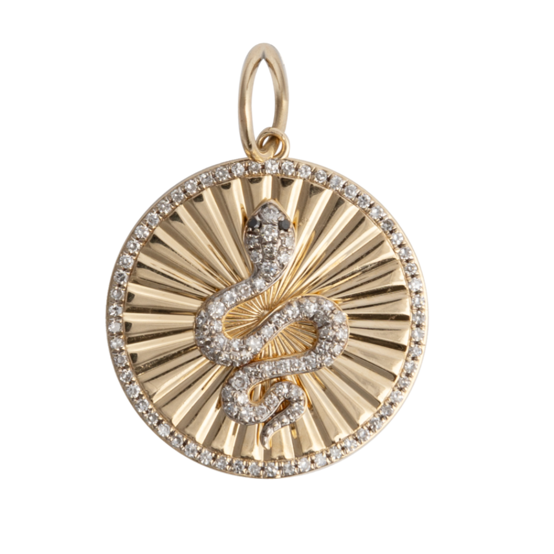 A 14k gold pendant featuring a diamond-set serpent with black diamond eyes, surrounded by a starburst pattern with diamond border.