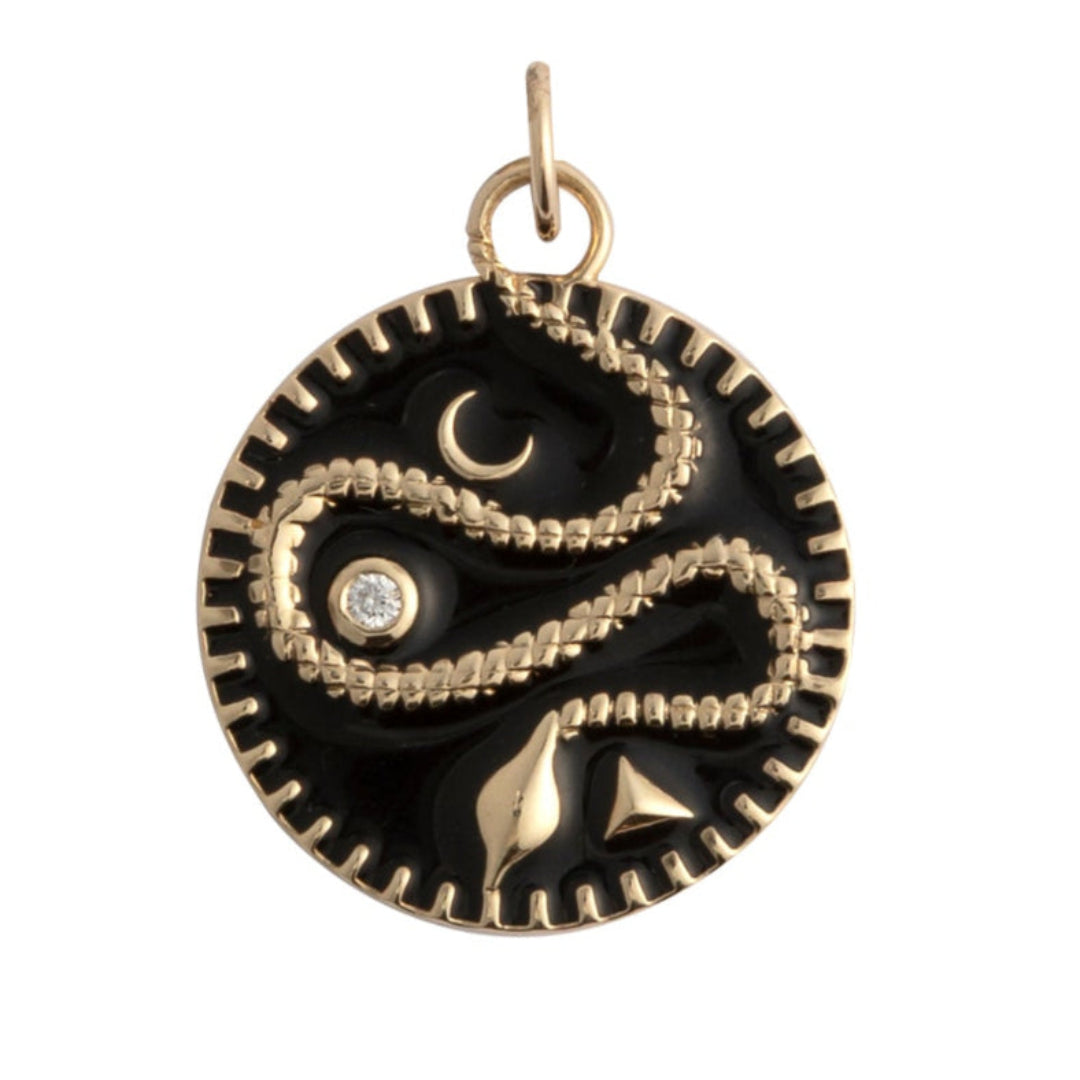 A black enamel pendant set in gold with a serpent and a diamond on a white background.