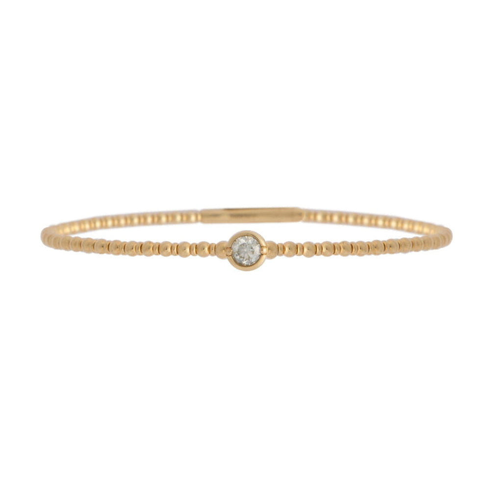 Gold bracelet with a single station diamond on a white background