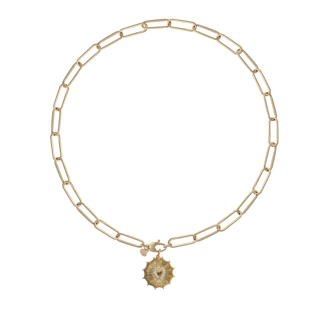 A 14k gold slim paperclip chain necklace with a gold sunrays pendant attached laid out on a white background.