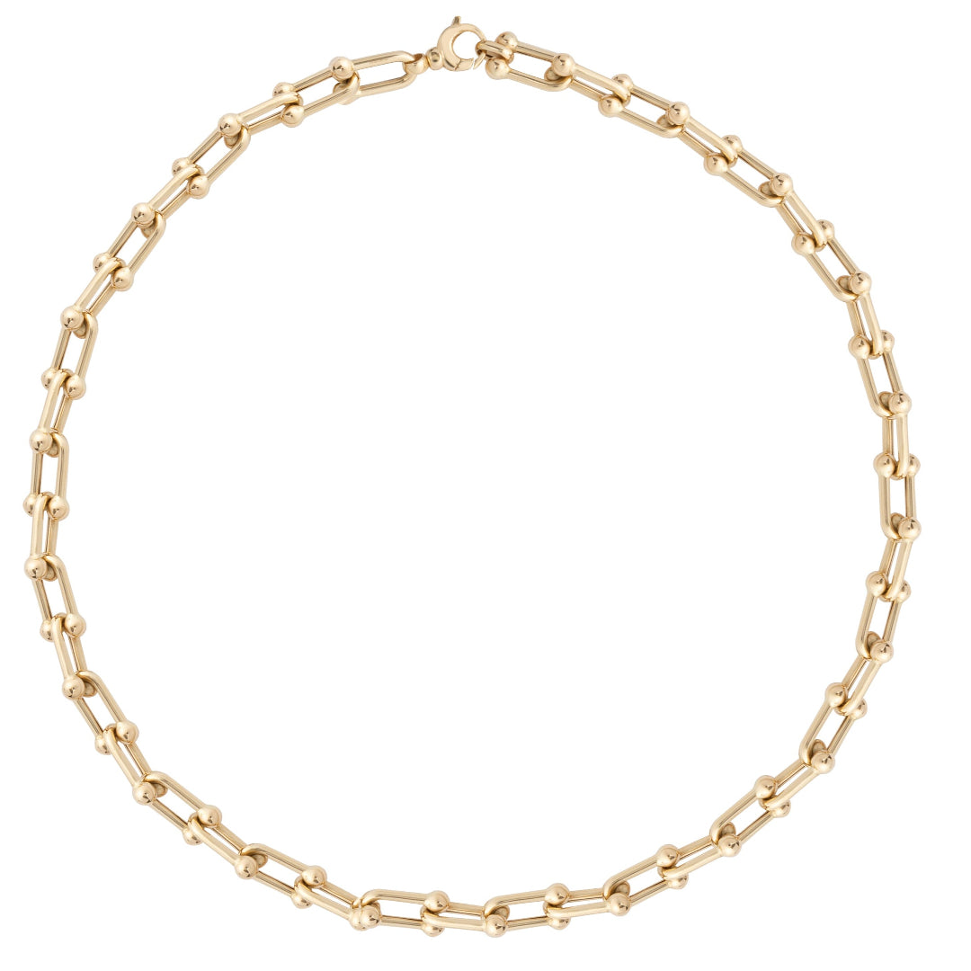 A chunky gold chain necklace with a clasp, displayed on a plain background.