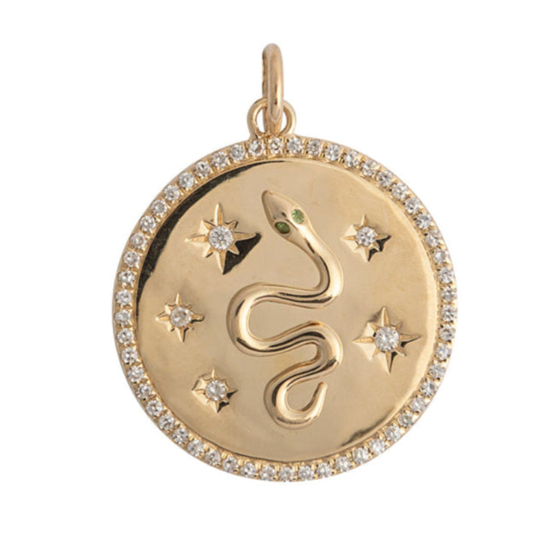 A 14k gold diamond pendant with a serpentine design, featuring emerald eyes and star details, surrounded by a circular band with diamond embellishments.