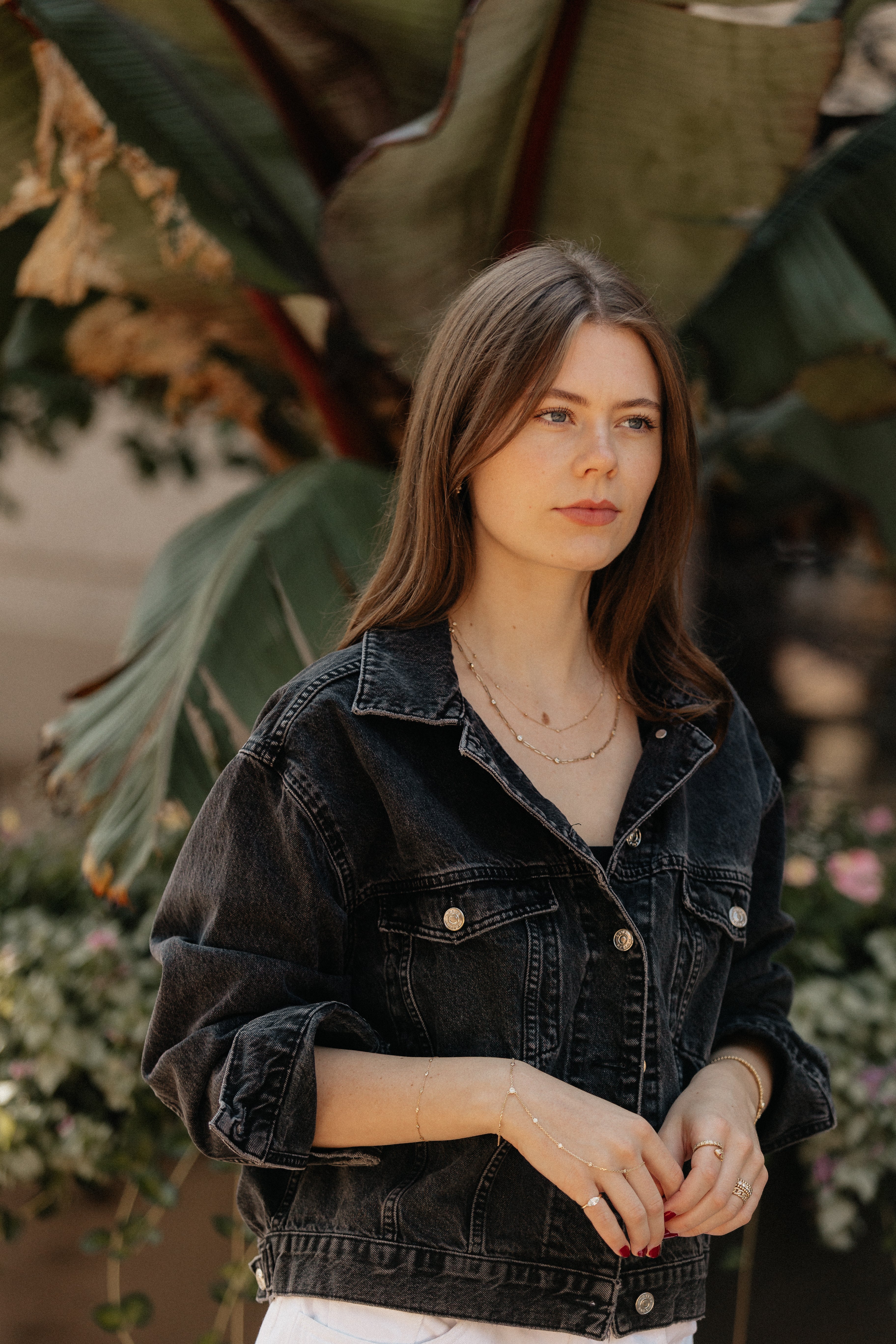 A person wearing numerous gold chains with a jean jacket