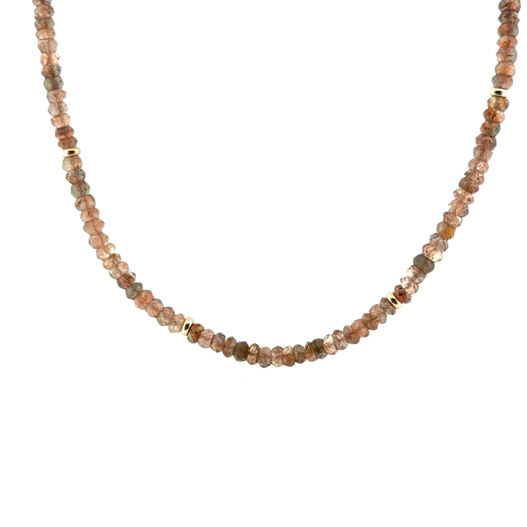 A close up of an Andalusite & Gold Bead Necklace on a white background. 
