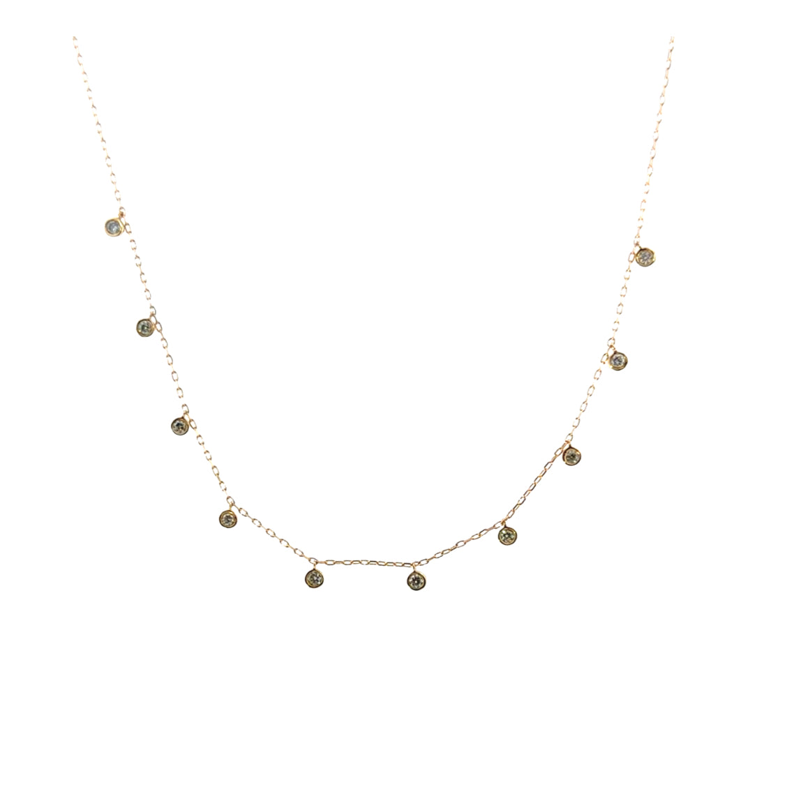 A delicate gold chain with bezel set diamonds suspended, on a white background. 