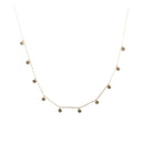 A delicate gold chain with bezel set diamonds suspended, on a white background. 