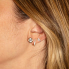 Close-up of an ear wearing a set of diamond earrings.