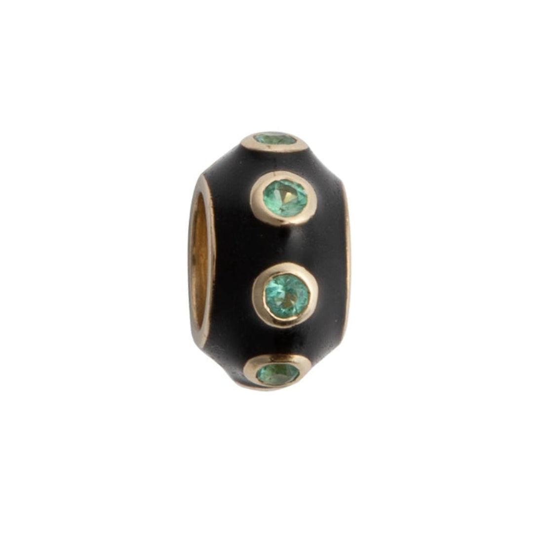 A black enamel and emerald roundel bead with gold accents, designed to be used as a charm or pendant.