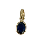 A blue sapphire pendant set in 14k yellow gold on a white background. 
