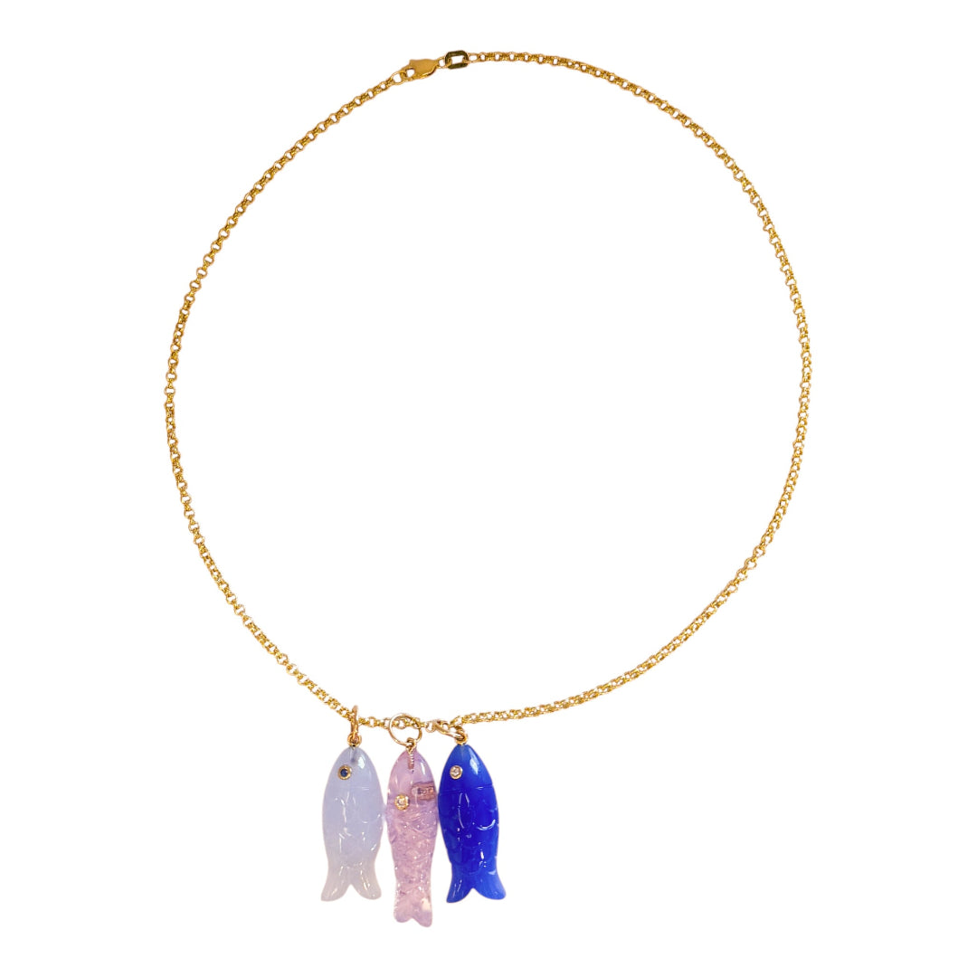Necklace with three colorful fish pendants on a gold chain against a white background