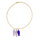 Necklace with three colorful fish pendants on a gold chain against a white background