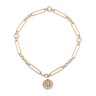 A 14k gold chunky mixed link chain with a gold and emerald pendant on a white background. 