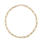 A chunky gold paperclip chain necklace laid out on a plain background.