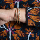 A person wearing three diamond bracelets, showcasing the side of the bracelets.