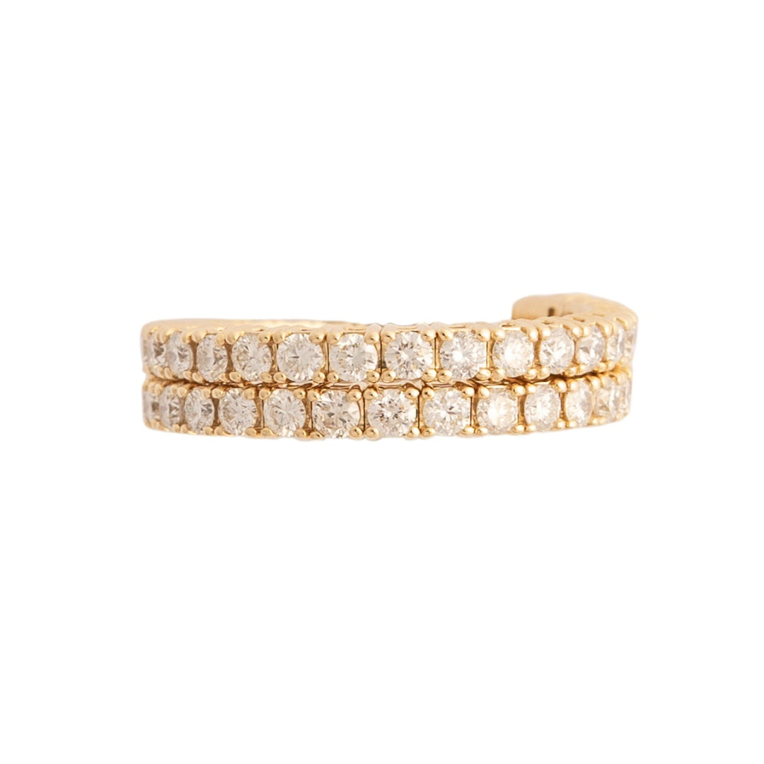 A gold flexi wrap around ring with diamond stones against a white background.