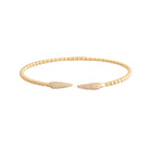 Gold bracelet with leaf-like ends on a white background