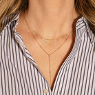 Gold necklace worn by a person with a striped shirt