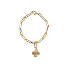 A 14k gold pendant featuring a blue sapphire center stone with clover-shaped rays around it attached to a paperclip chain bracelet. 
