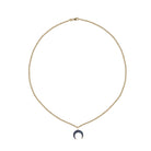Gold necklace with a crescent moon pendant on a white background